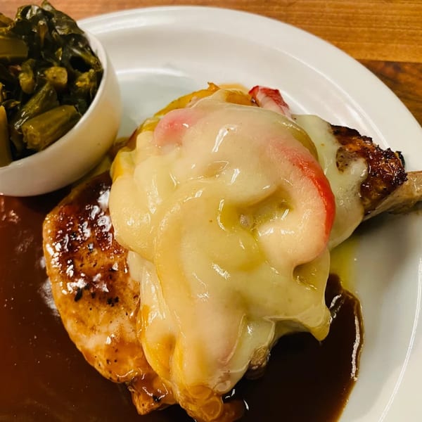 Southern-style chicken with melted cheese and ham, served with collard greens and gravy.