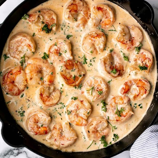Annie O's Kitchen's creamy southern shrimp, garnished with fresh parsley, in a cast iron skillet.